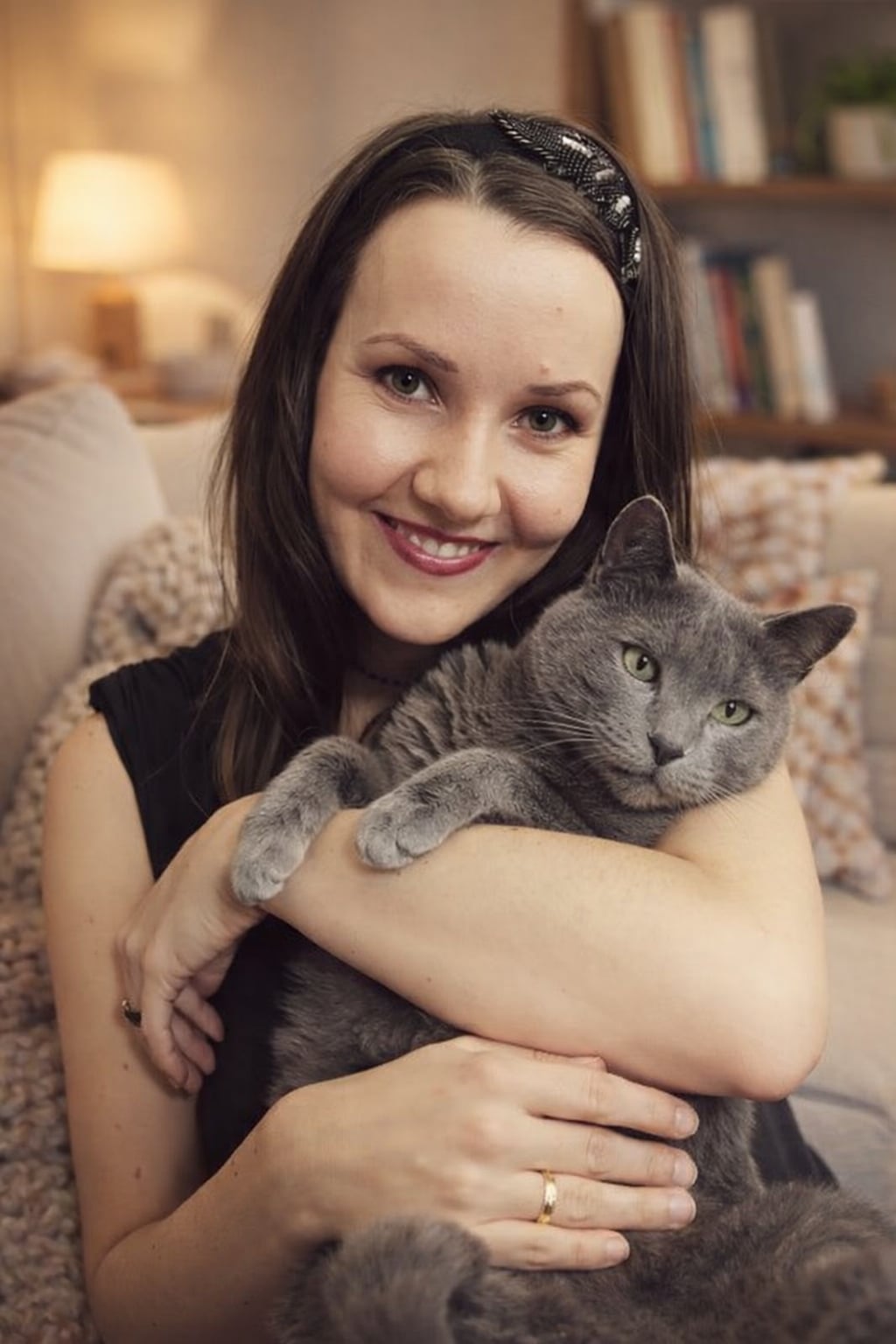 Kobieta trzymająca kota w oknie